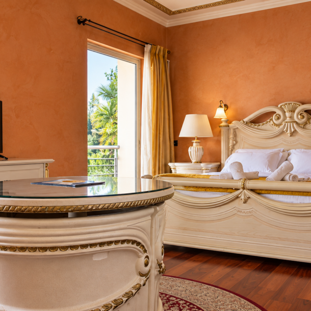 Luxurious suite interior with custom baroque furniture, terracotta walls, and a balcony at Anastazia Luxury Suites & Spa