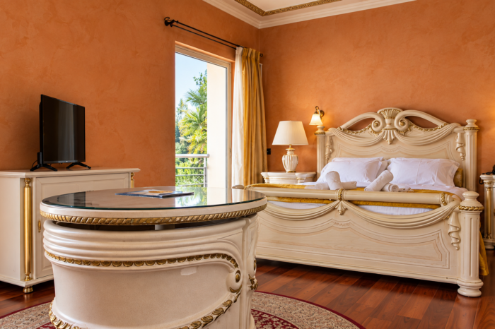 Luxurious suite interior with custom baroque furniture, terracotta walls, and a balcony at Anastazia Luxury Suites & Spa