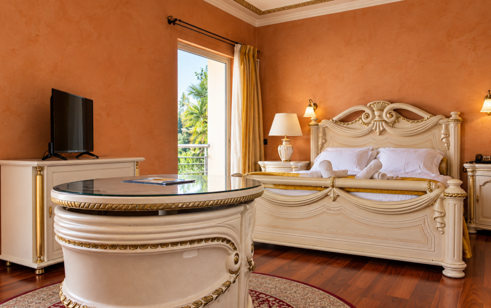 Luxurious suite interior with custom baroque furniture, terracotta walls, and a balcony at Anastazia Luxury Suites & Spa