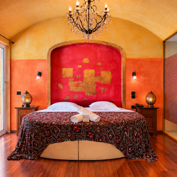 Executive Suite bedroom featuring a luxurious round bed and a crystal chandelier at Anastazia Luxury Suites & Spa