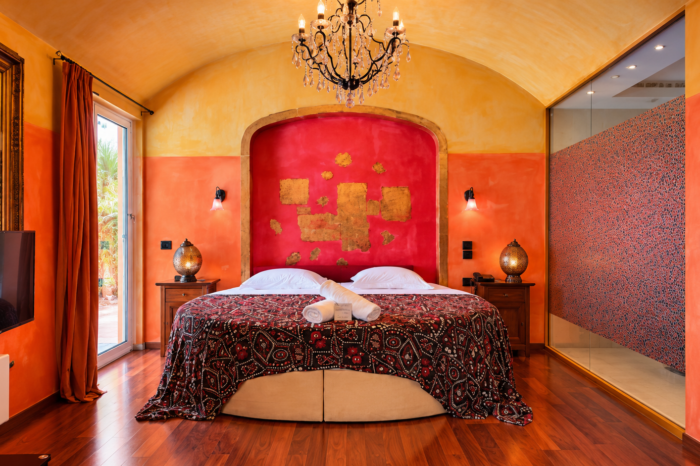 Executive Suite bedroom featuring a luxurious round bed and a crystal chandelier at Anastazia Luxury Suites & Spa